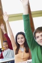 Students raising their hands in class